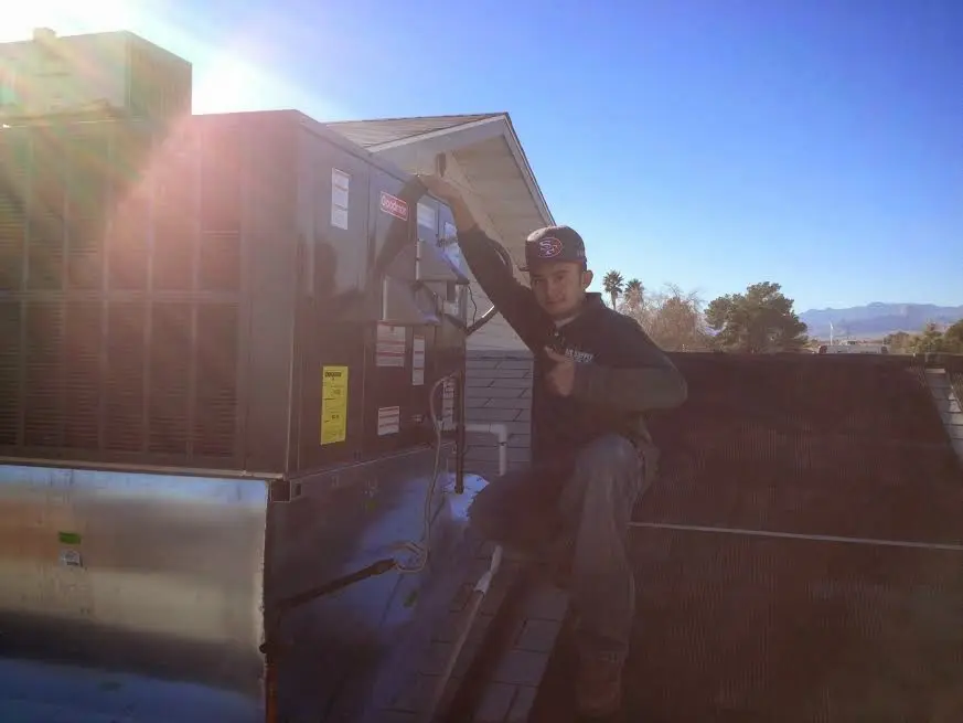 HVAC technician performing HVAC Inspection on a rooftop unit in Emporia